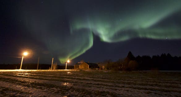 photo of view of Young girl walking with snow shoes looking over vast landscape in horizon. View over Skellefteå, Sweden.