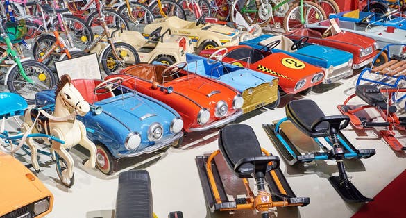 Photo of toy cars with pedals, sleds, bicycles from the USSR in retro museum, Varna, Bulgaria.