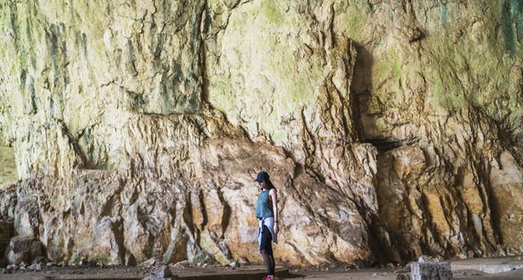 Photo of women exploring a devetashka cave near lovech, Bulgaria.