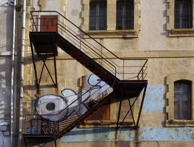 Industrial building with an exterior fire escape in Marseille, reflecting the city’s creative and repurposed urban spaces..jpg