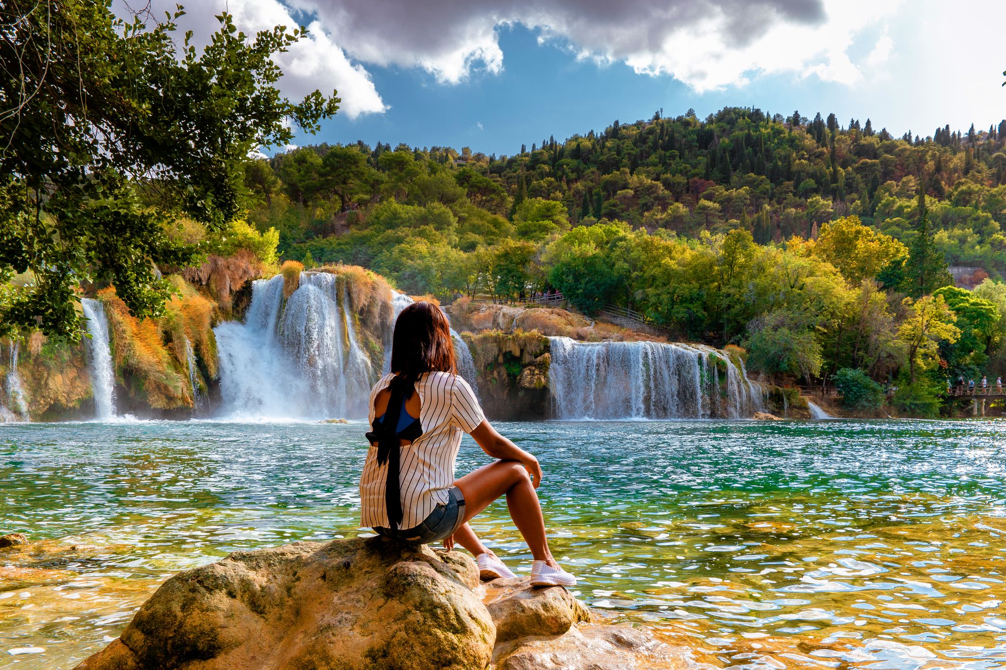 Photo of woman relaxing in the park of the krka national park Croatia on a bright summer evening.