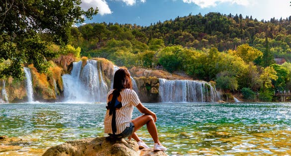 Photo of woman relaxing in the park of the krka national park Croatia on a bright summer evening.
