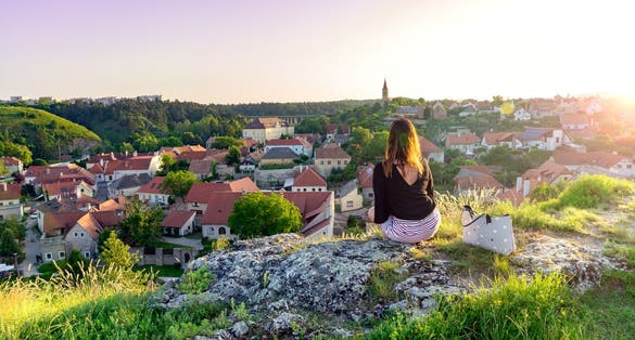 The green hill garden in the middle of old town Veszprém, Hungary with a woman sitting on the cliff enjoying the view