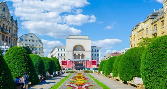 Photo of Victory square, piata victoriei Timisoara is a long square with green park surrounded by national opera on one side and the metropolitan cathedral on the other.