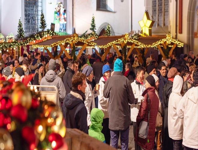 Crowds enjoying festive lights and market stalls at the Lucerne Christmas Market in Switzerland..jpg
