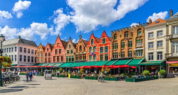 Traditional Flemish-Baroque-style townhouses buildings with colourful facades and street restaurants on Market square in Brugge old town, Bruges city historical centre, Flemish Region, Belgium