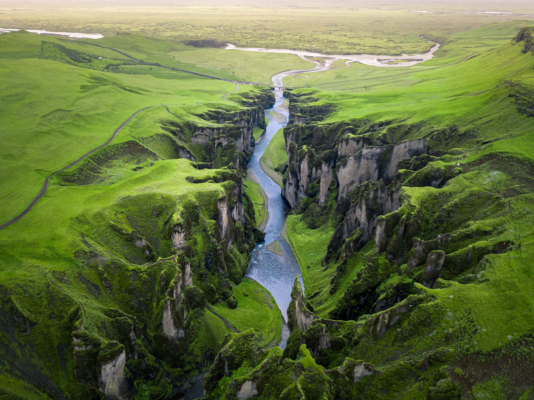 photo of unique rugged landscape of Fjaðrárgljúfur canyon covered by beautiful green moss, located in southern Iceland. Aerial shot.