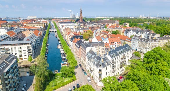 Photo of beautiful aerial view of Nyhavn historical pier port and canal with color buildings and boats in the old town of Copenhagen, Denmark.