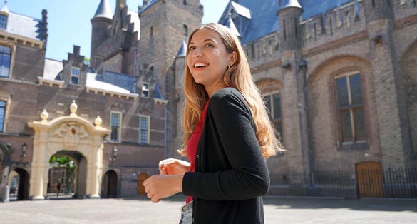 photo of young student girl visiting the complex of buildings of Binnenhof in the Hague, Netherlands.