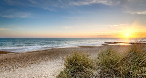 Photo of sunset over sand dunes at Hengistbury Head beach near Bournemouth in Dorset.