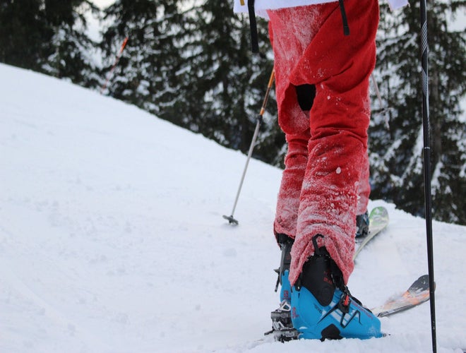 Person in a Santa suit skiing uphill through snow in the Swiss Alps..jpg
