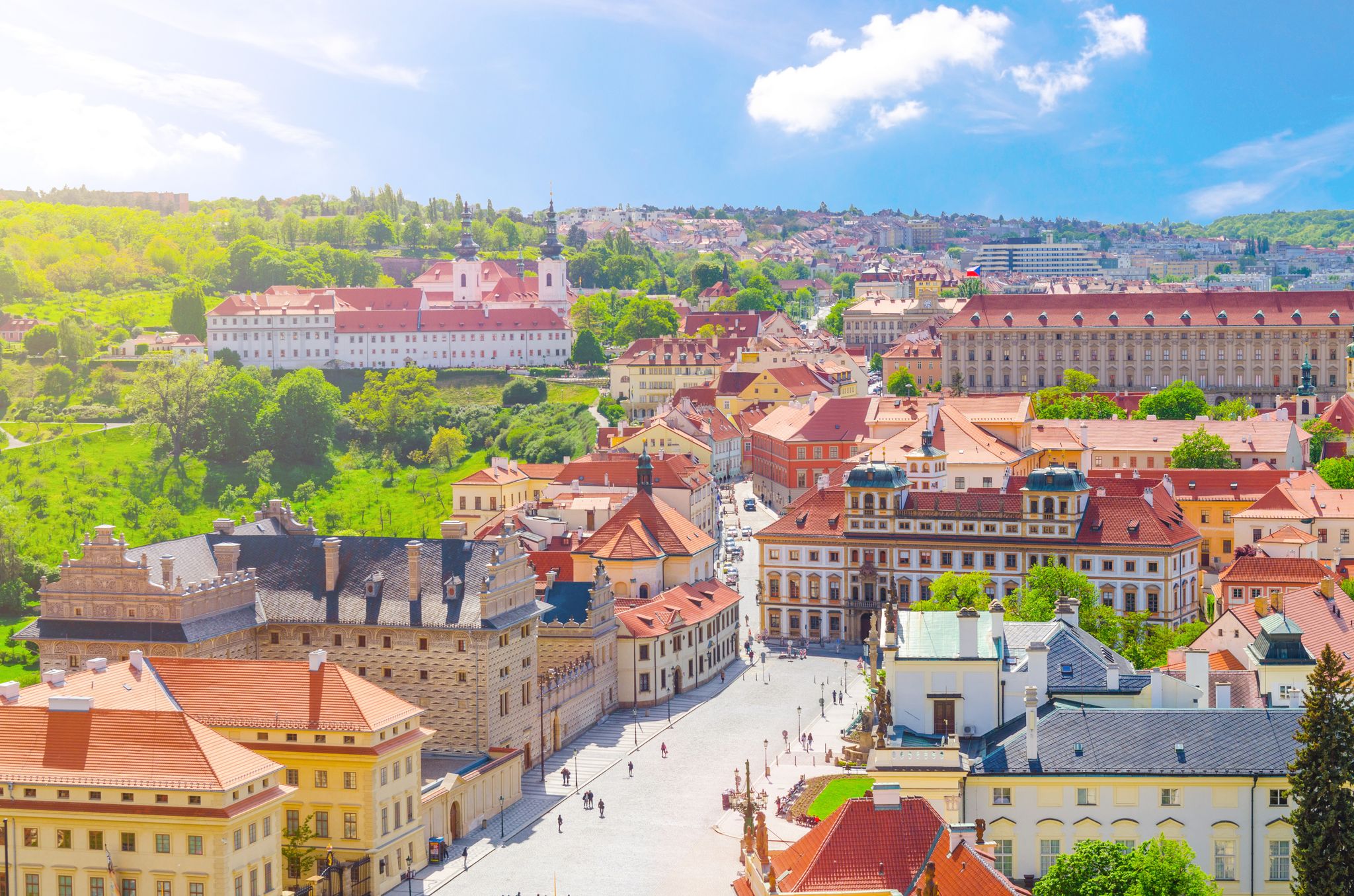 Photo of aerial view of Prague Castle district with Hradcany Square, green gardens on slope of hill, Schwarzenbersky and Toskansky palace, Czech Republic.