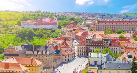 Photo of aerial view of Prague Castle district with Hradcany Square, green gardens on slope of hill, Schwarzenbersky and Toskansky palace, Czech Republic.