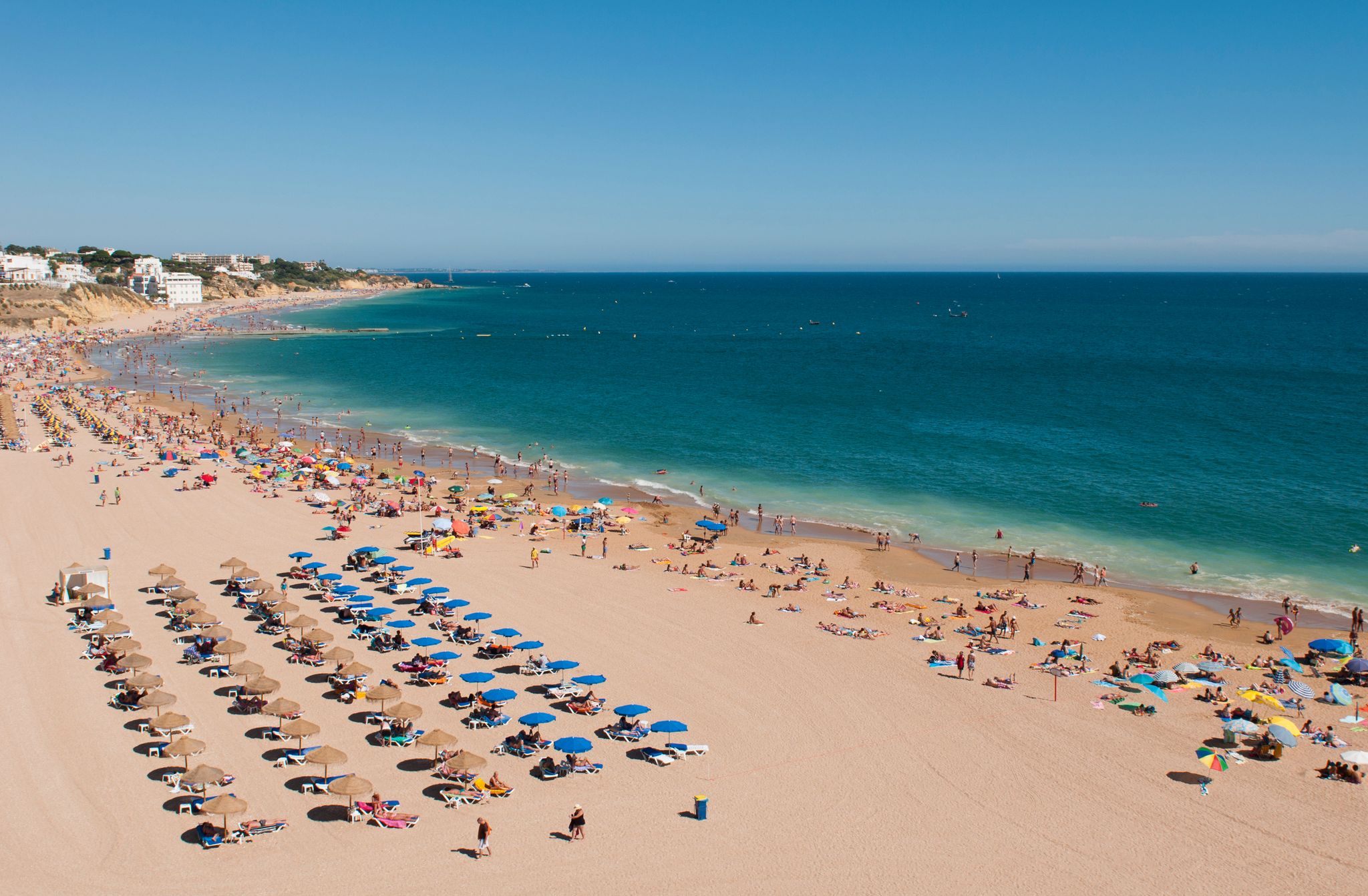 Photo of wide sandy beach in white city of Albufeira, Algarve, Portugal.