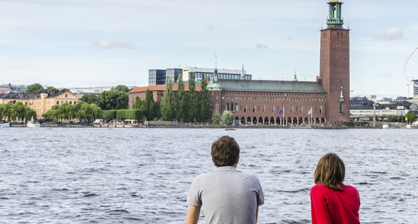 photo of man with a girl opposite the Stockholm City Hall (Stadshuset) in Stockholm, Sweden.