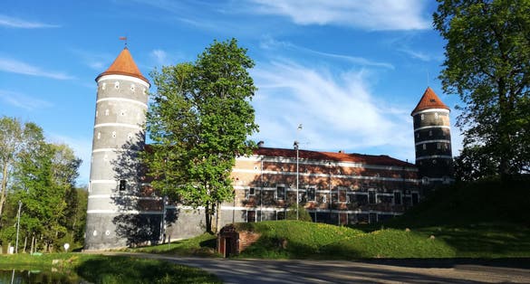 Panemune Castle with green trees and blue sky. Castle on the right bank of the Nemunas river, in Vytėnai, Jurbarkas district, Lithuania. One of the most beautiful Renaissance era building in Lithuania