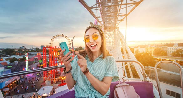 Photo of happy tourist enjoying the Wiener Riesenrad or Vienna Giant Wheel 65m tall Ferris wheel in Prater park in Austria.