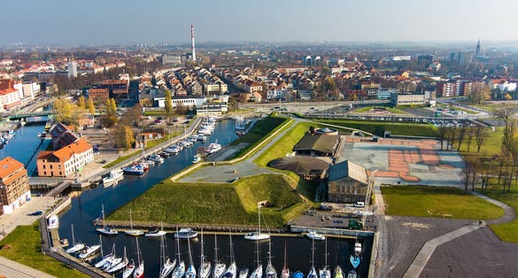 Aerial view of beautiful yachts by the pier in the yacht club in Klaipeda, Lithuania. Klaipeda old castle site. Autumn view of Dane river.