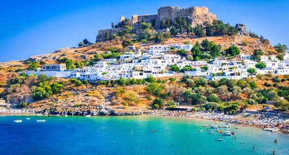 Photo of landscape with beach and castle at Lindos village of Rhodes, Greece.