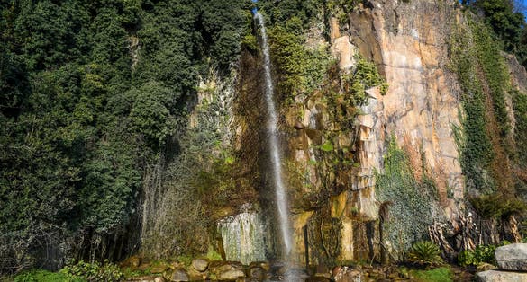 photo of Jardin Extraordinaire a garden with a waterfall, rocks and lush vegetation in Nantes, France.