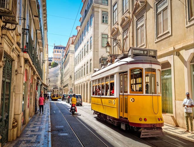 Tram 28 passing through the historic streets, a must-see highlight in Portugal in August..jpg