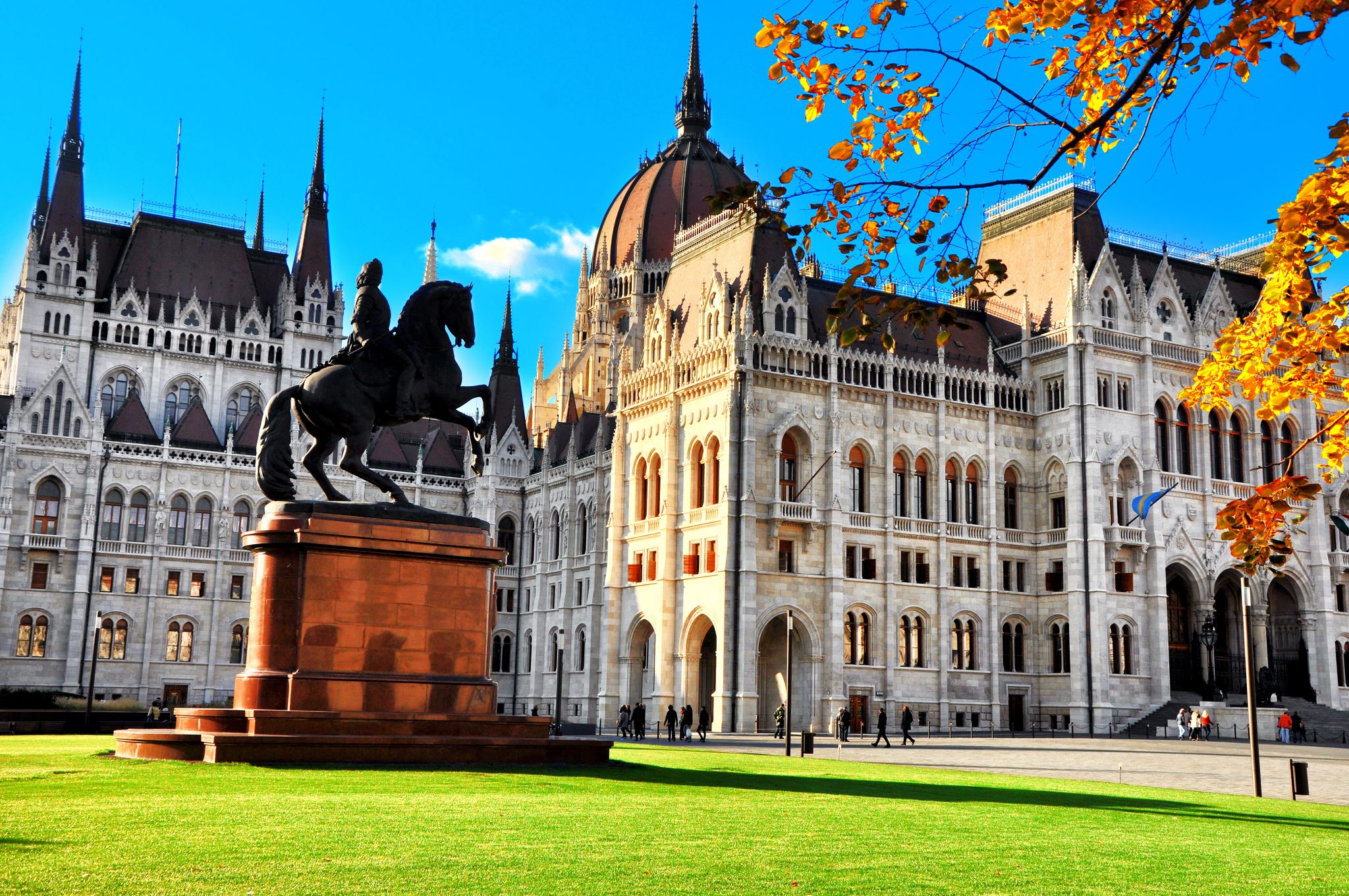 Photo of City park with equestrian statue of Ferenc Rakoczi II in Parliament Square outside the Parliament Building built in Neo-Gothic style and located on the bank of Danube in Budapest Hungary.