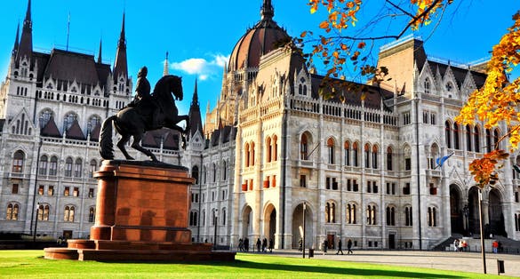 Photo of City park with equestrian statue of Ferenc Rakoczi II in Parliament Square outside the Parliament Building built in Neo-Gothic style and located on the bank of Danube in Budapest Hungary.