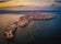 Siracusa, Ortigia Island from the air at sunset, Sicily, Italy. Isola di Ortigia, coast of Ortigia island at city of Syracuse, Sicily, Italy. Aerial view. June 2023