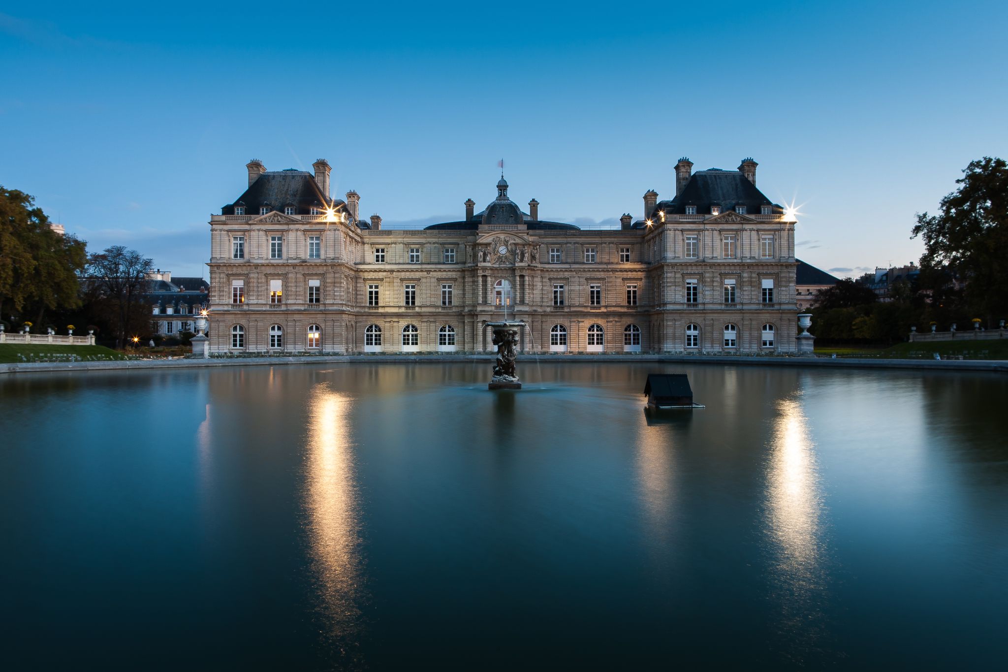 photo of The Luxembourg Palace in The Jardin du Luxembourg or Luxembourg Gardens at blue hour in Paris, France.