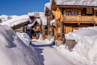 Wooden houses or chalets in Zinal, Switzerland on a beautiful day with a lot of snow. Zinal is a village in Switzerland, located in the municipality of Anniviers in the canton of Valais