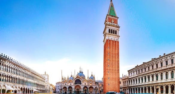 photo of sunrise in san marco square with campanile and san marco's basilica. Panorama of the main square of the old town. Venice, Italy.