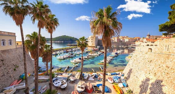 Photo of historic Dubrovnik. Colorful harbor of Dubrovnik and stone defense walls view.