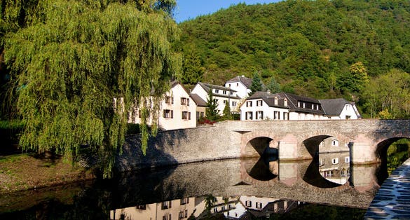 Medieval Village Esch sur Sure with Classical Houses and Bridge over Reflection in Sunny Day on Blue Sky background Outdoors. Diekirch, Luxembourg