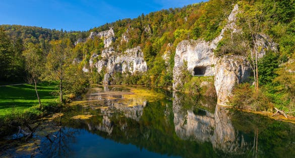 Panoramic view of Danube river valley near Sigmaringen, Germany. Limestone cliffs, colorful foliage and clear water reflecting idyllic scenery. Road between Dietfurt and Gutenstein with tunnels.