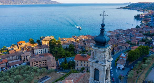 photo of view of Parrocchie di Gargnano church tower in italy. Top view of a cosy Italian fishing village, Brescia, Italy.