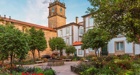 photo of  view of Small square in Santiago de Compostela city with flower garden and fountain, Galicia, Spain. Popular touristic landmark