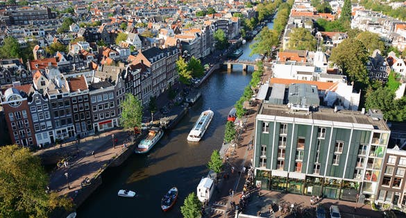 Photo of aerial view from the Westerkerk to the Anne Frank House and Canal with boats in Amsterdam.