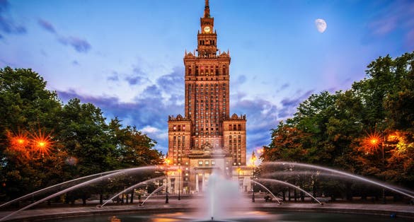 Photo of Palace of Culture and sciences at night one of the main travel attractions ,the Main symbol of Warsaw with Fountain Close Up, Warsaw, Poland.