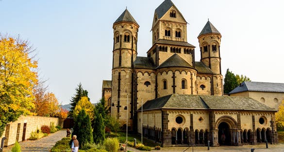 photo of view of Maria Laach Abbey in Germany. Autumn landscape. The medieval church in autumn forest, Gless, Germany.