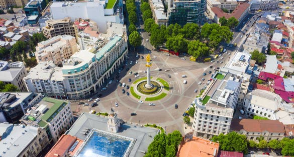 photo of an aerial view of Tbilisi, Georgia. Liberty Monument Depicting St George Slaying The Dragon And Tbilisi City Hall In Freedom Square In City Center. Famous Landmark.