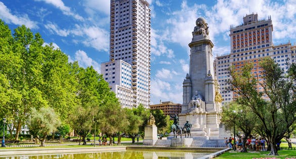 Photo of The Cervantes monument, the Tower of Madrid (Torre de Madrid) and the Spain Building (Edificio Espana) on the Square of Spain (Plaza de Espana). 