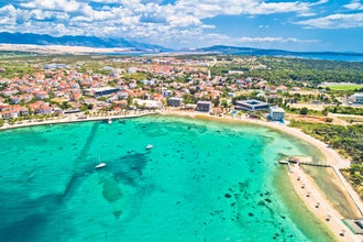 Town of Novalja beach and waterfront on Pag island aerial view, Dalmatia region of Croatia