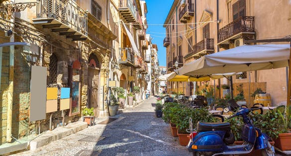 Narrow street in the old town of Cefalu in Sicily, Italy in a beautiful summer day