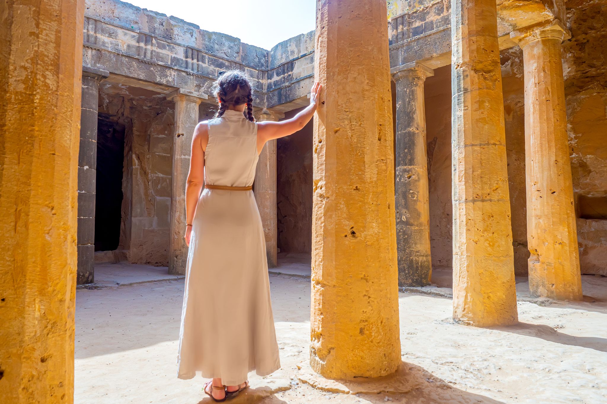 Photo of girl tourist in the necropolis catacombs. Paphos archaeological memorial. Touristic sightseeing Cyprus.