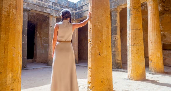 Photo of girl tourist in the necropolis catacombs. Paphos archaeological memorial. Touristic sightseeing Cyprus.
