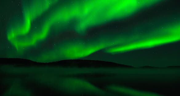 Photo of beautiful green aurora borealis in Finnish lapland.