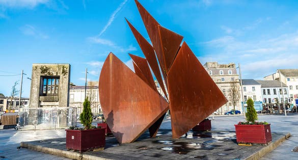 Photo of fountain depicting Galway Hookers in Eyre Square with Browne doorway in background in Galway, Ireland.