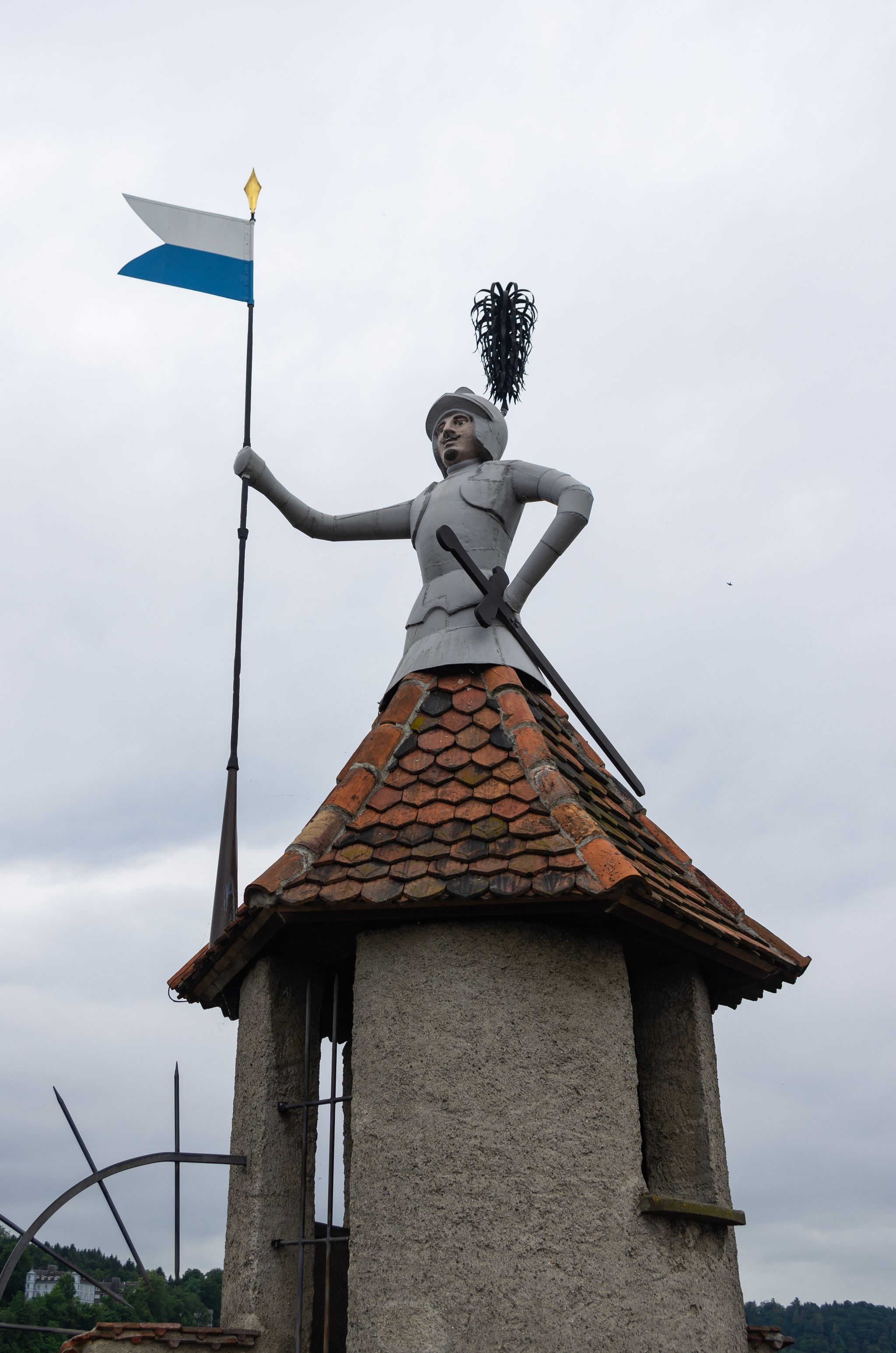 photo of the “Iron Man” statue on Männliturm tower on old defense wall in Lucerne, Switzerland.