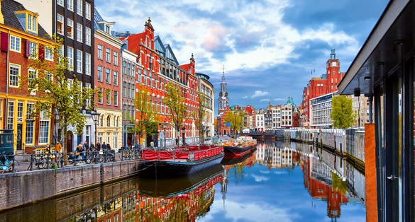 Channel in Amsterdam Netherlands houses river Amstel landmark old european city spring landscape.