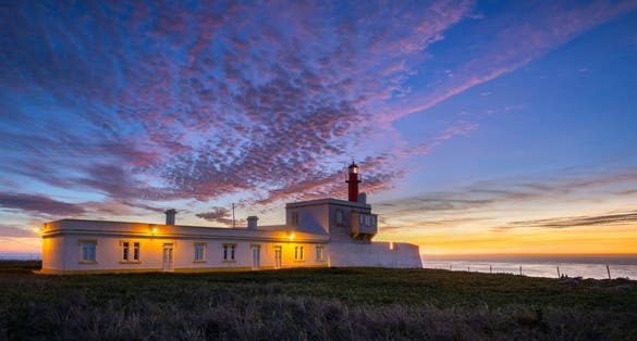 Photo of Lighthouse at Cape Cabo Raso near the city of Cascais, Portugal, after sunset.